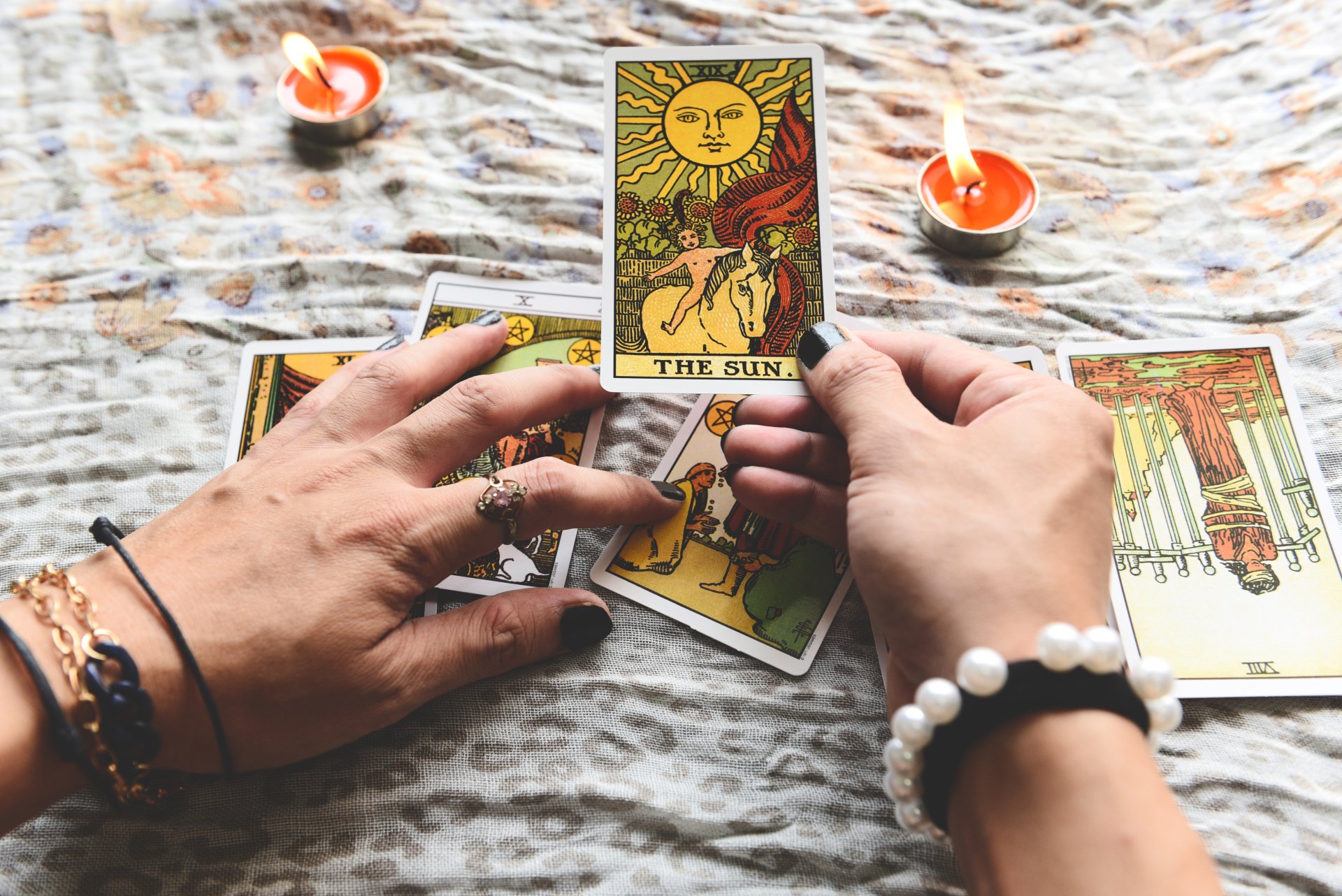 Show fortune tellers of hands holding tarot cards and tarot read